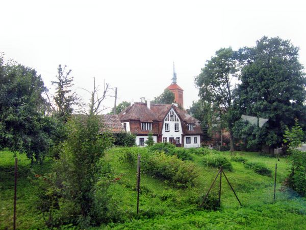 Kolno-zabytkowy domek,w tle wieża kościoła z XIV wieku. 2012-07-09