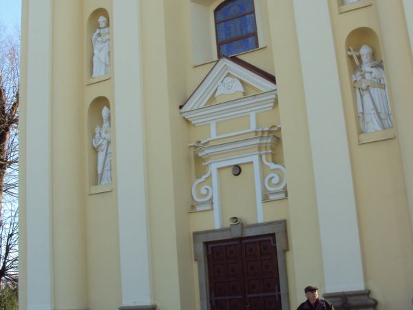 przed kościołem pw. św. Mikołaja z 1 poł. XVIIIw. W fasadzie posiada dwie wieże, we wnękach tych wież cztery rzeźby z XIXw. Nad gł. wejściem "Oko Opatrzności".