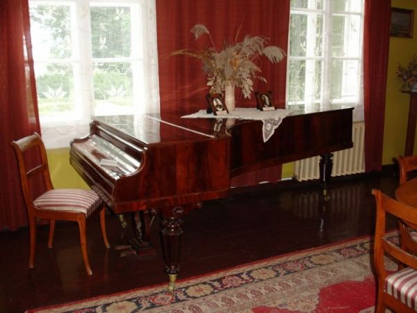 Wewnatrz dworu - muzeum  ekspozycja wnętrz domu ziemiańskiego oraz pokoje gościnne.