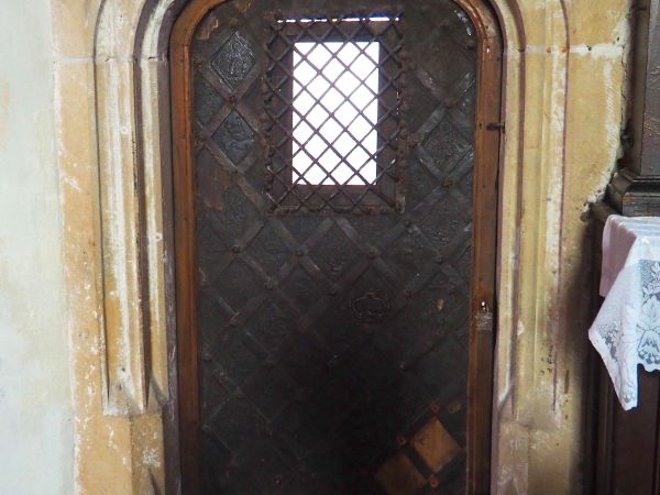 portal - dwuramienny, w nim osadzone drzwi gotyckie, z okratowanym okienkiem, pola połączone żelaznymi listwami, mocowanymi za pomocą ozdobnych ćwieków.