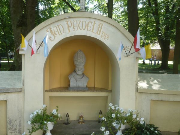 W okół  kościoła małe groty w jednej z nich rzeżba Jana Pawła II autorstwa  Piotra Chmielowiec,z okazji 800- lecia parafii.