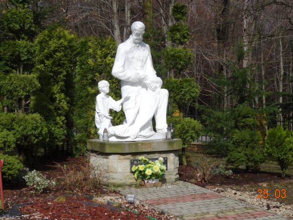 rzeźba przedstawiająca bł. Edmunda Bojanowskiego - założyciela Zgromadzenia Sióstr Służebniczek, udzielającego wspomożenia potrzebującej matce z dzieckiem.