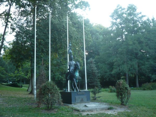 Jeszcze jedno ujęcie pomnika Tatara na tle parku.