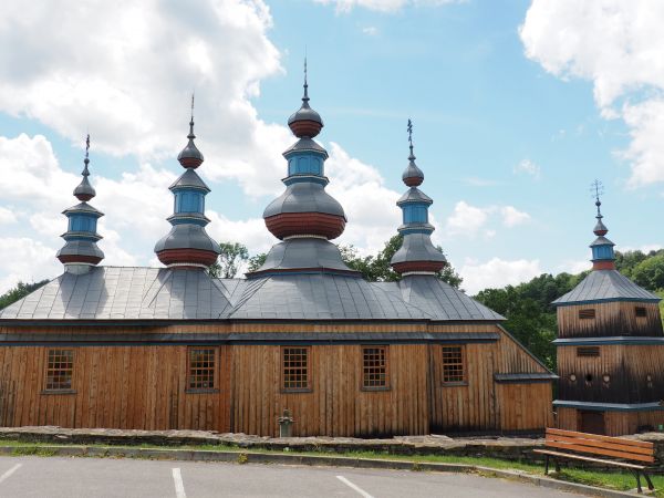 cerkiew po odbudowie, po prawej silnie osmolona w wyniku pożaru dzwonnica nakryta nowym blaszanym dachem, pięknie prezentują się wieże a w nich tzw. "pozorne la