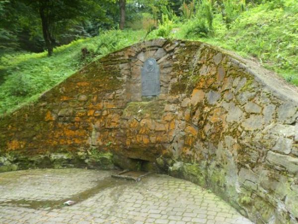 źródełko Szopena - obudowane piaskowcem z płytą z brązu z inskrypcją  i wizerunkiem - dla upamiętnienia genialnego kompozytora, którego imię nosiła nowa - przył