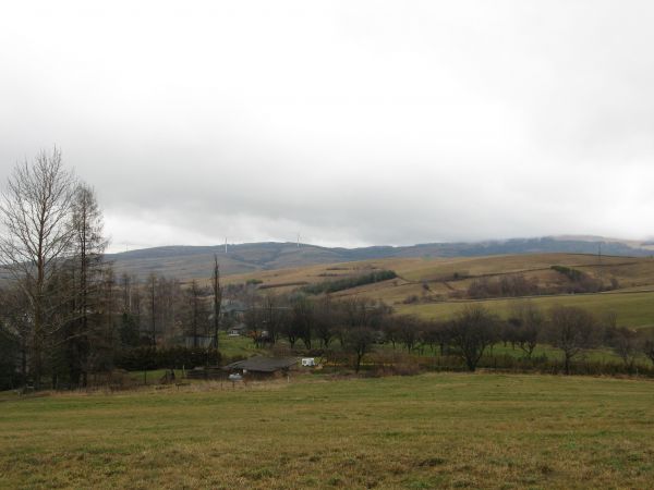 widok na grzbiety pasma Moczywa z najwyższym wzniesieniem Wilcze Budy -  759m npm, z farmą wiatrową a po prawej w dolinie wieś Tokarnia /jest galeria - zaprasza