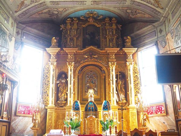 ołtarz główny i polichromia sklepień pokryta jest patyną czasu a szarawy koloryt potęguje panujący w świątyni nastrój powagi, dostojeństwa i harmonii.