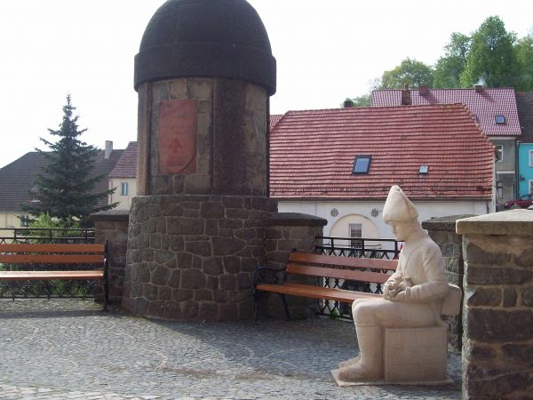 Pomnik żołnierski i kamienna sylwetka żołnierza.