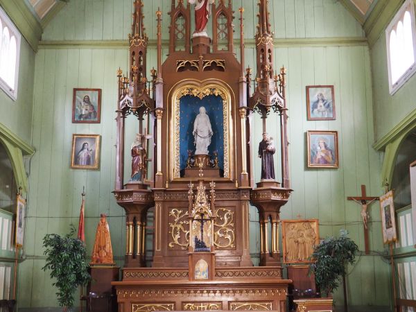 ołtarz główny kościoła zdrojowego - neogotycki, drewniany z figurą Matki Boskiej Uzdrowienia Chorych w otoczeniu świętych, wyżej stoi figura Chrystusa.