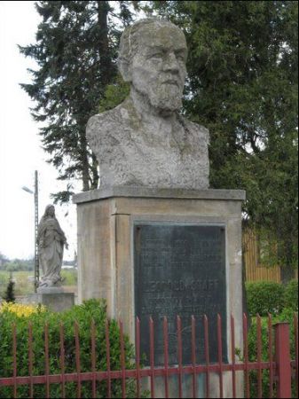 Przed budynkiem plebanii popiersie Leopolda Staffa.