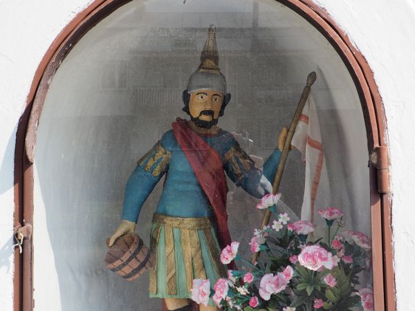 zabytkowa kapliczka przydrożna - wewnątrz za oszklonymi drzwiczkami stoi ludowa figura św. Floriana.