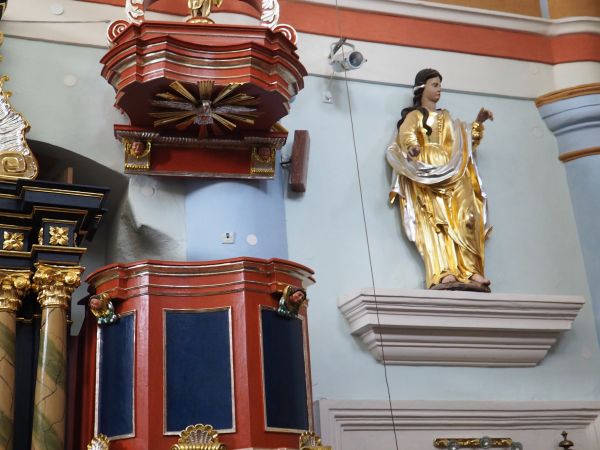 ambona - z korpusem ozdobionym główkami aniołków, baldachim zwieńczony wolutami z rzeźbą Chrystusa Zmartwychwstałego i glorią, w podniebiu Duch Św. w postaci go