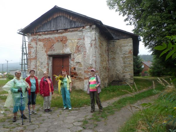 przed wejściem do cerkwi greckokatolickiej pw. Zaśnięcia Przeczystej Bogarodzicy, z 1901r. w stanie opuszczonej a zarazem postępującej ruiny, po II w.św. zamien