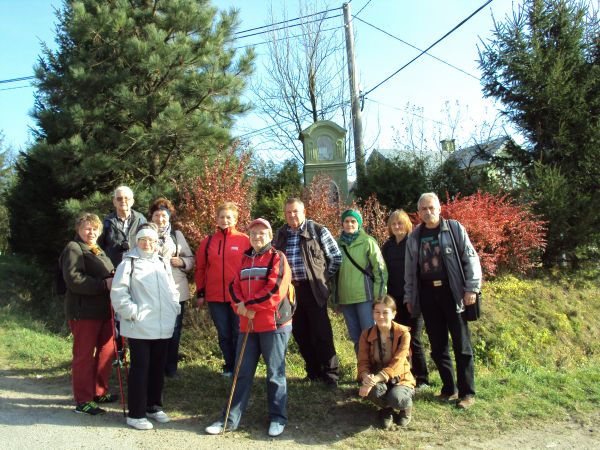 "ślady wiary" naszych przodków utrwalają, o narodowej kulturze i tradycji świadczą - kapliczki przydrożne, tu: przed jedną z licznych w tej wsi.