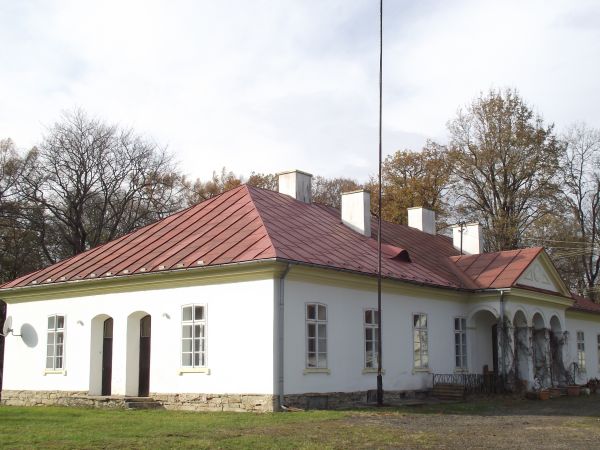 główny obiekt założenia dworsko-parkowego - widok od strony parku i stawu. Budynek w kształcie prostokąta, parterowy z podpiwniczeniem, elewacja frontowa wspart