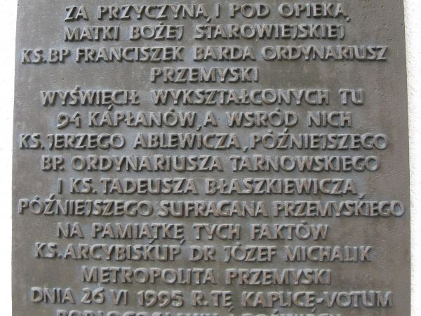 tablica ufundowana przez żyjących księży - wychowanków leśnego seminarium - na fasadzie kaplicy - votum.