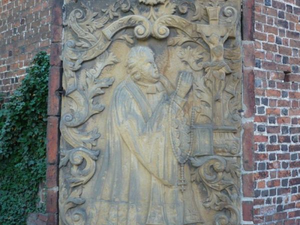 Na ścianach zewnętrznych epitafia wczesnobarokowe z piaskowca.