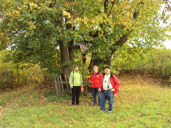 przy krzyżu - z kapliczką szafkową, w której Grupa Pasji, ludowa, wiek XX. Przydrożny, na rozstajach, na przysiółku "Nowiny", drogi prowadzą do wsi: Końskie, Dę