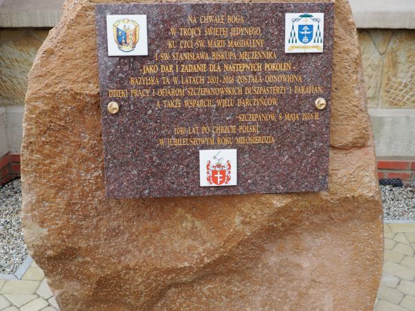 głaz a na nim tablica z tekstem honorującym rocznice, świątynię i jej odnowienie w Jubileuszowym Roku Miłosierdzia - przy murach kościoła.