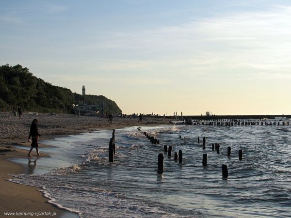 Widok z szerokiej plaży w Pogorzelicy na latarnię morską w Niechorzu