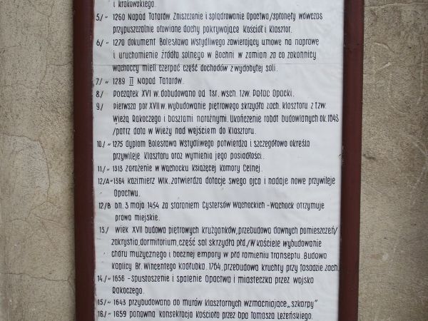 na murach klasztoru - tablica a na niej dzieje tutejszego opactwa cystersów.