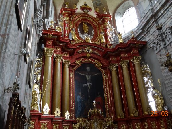 w bogatym wnętrzu kolegiaty : okazały ołtarz główny , w nim obraz ze sceną Ukrzyżowania.