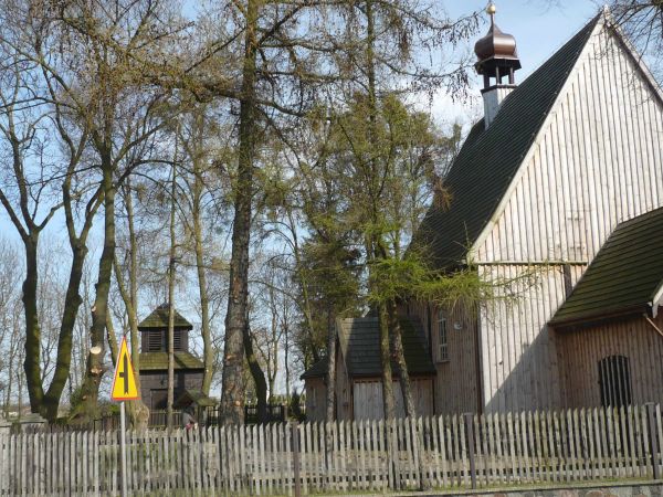 Inne ujęcie kościółka obok dzwonnica z 1789r i dzwony datowane na 1555r i 1752rprzy ogrodzeniu rzeźba Chrystus Frasobliwy.