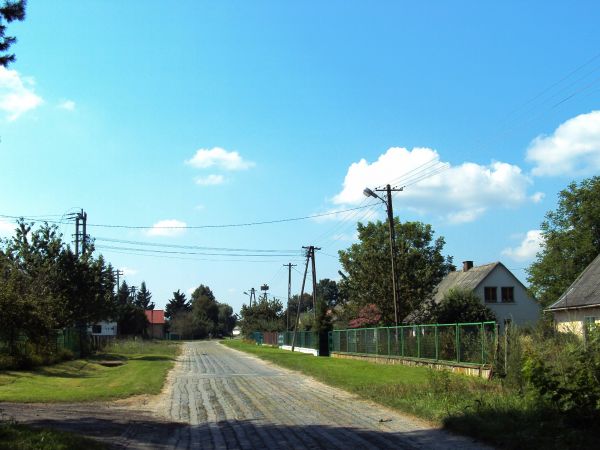 Za małym lasem, dalsze zabudowania wioski.