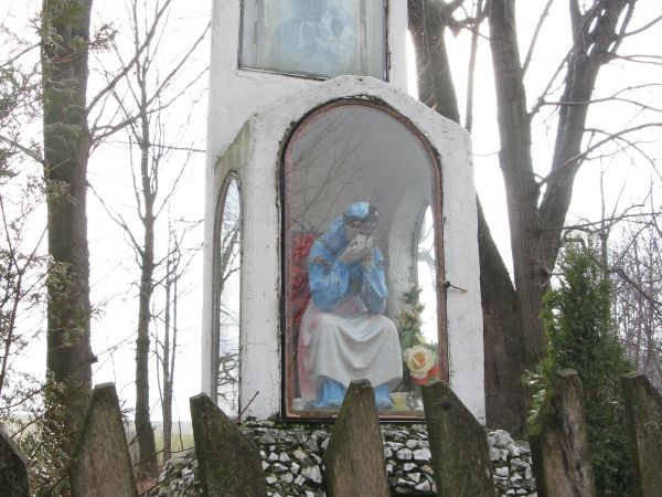 na placu po cerkwi: kaplica z Matką Boską Saletyńską - w niszy głównej oraz Obrazem Matki Boskiej Częstochowskiej - w płycinie, zwieńczenie krzyżem.
