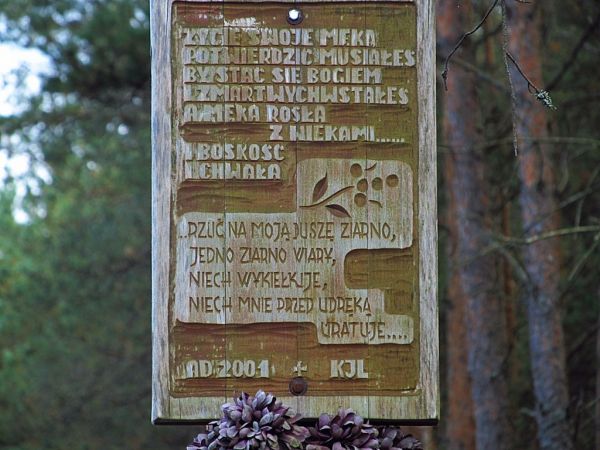 Tablica na krzyżu przy przejeździe kolejowym