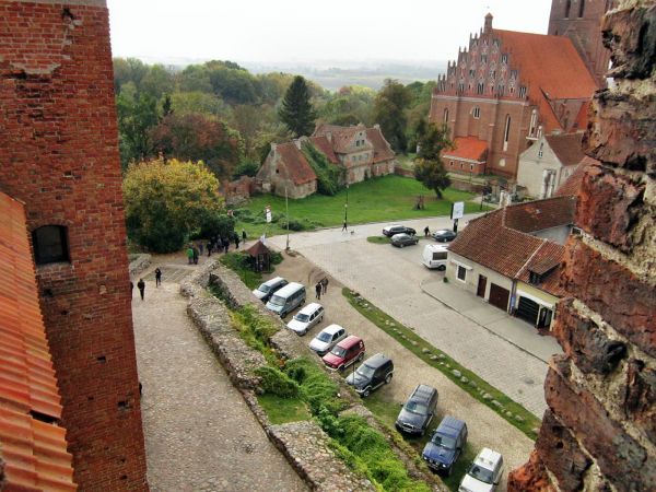 Widok z okna wieży zamku w kierunku Starej Plebanii za którą rozciąga się reszelski park w głębokiej dolinie.