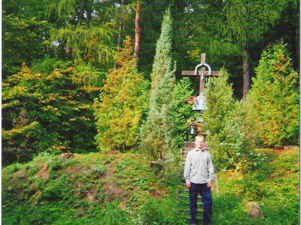 na zdjęciu: przed/obok krzyża wotywnego na skraju lasu, przy ul. Gajowej do wsi Liszna zmierzającej, nad byłym poligonem. Z informacji przewodnickich wynika, iż