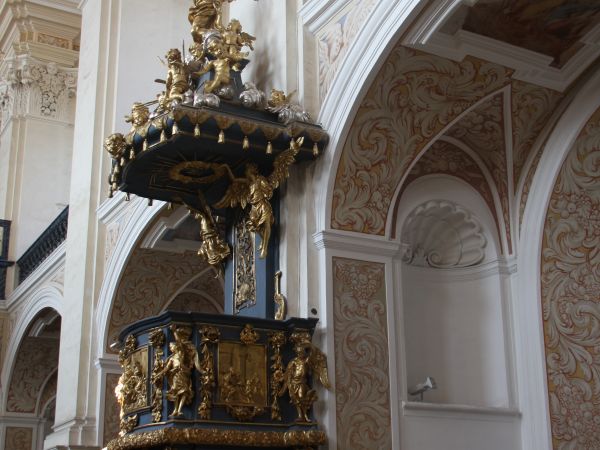 Kościół otrzymał układ halowo-emporowy: po obu stronach nawy głównej umieszczono rzędy kaplic - n/z ambona, pięknie ubogacona a jej baldachim wieńczy figura Bog