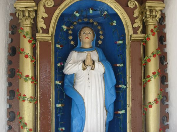 Figura Matki Boskiej Różańcowej - uposażenie kapliczki - przy głównym trakcie, szacunek do treści i symboliki chrześcijańskich często jest gloryfikowany.