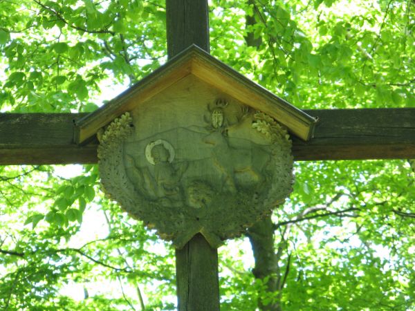 na drzeworycie scena ze św. Hubertem klęczącym przed jeleniem, święty ten jest patronem myśliwych, leśników, strzelców a także lunatyków i chorych na epilepsję,
