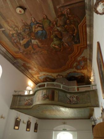 malowidło na suficie przedstawia scenę "Zesłanie Ducha Świętego", dalej : chór i organy, boazeria chóru zdobiona malowidłami biblijnymi z aniołami.