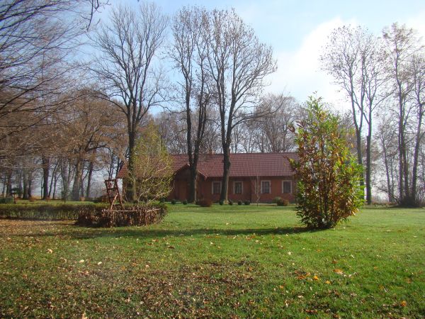 przed budynkiem dawnego folwarku - "w Chmurówkach" , w parku częste nasadzenia drzew i krzewów "egzotycznych".