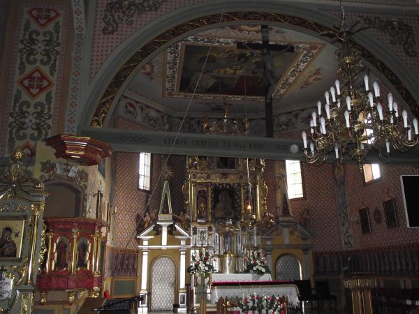 po lewej: ambona z 1717r. barokowa z malowidłami ewangelistów na parapecie. Pod prezbiterium kościoła  w krypcie grobowej pochowany Zyndram z Maszkowic, rycerz,