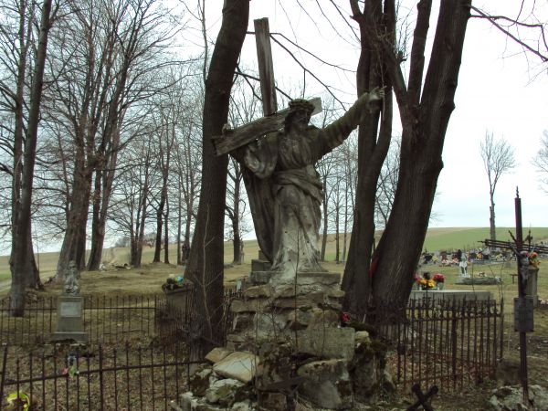 ogrodzone płotkiem miejsce pochówków rodziny Morawskich - kiedyś właścicieli wsi i dworu - z postumentem nagrobnym, obeliskiem zwieńczonym rzeźbą Chrystusa dźwi