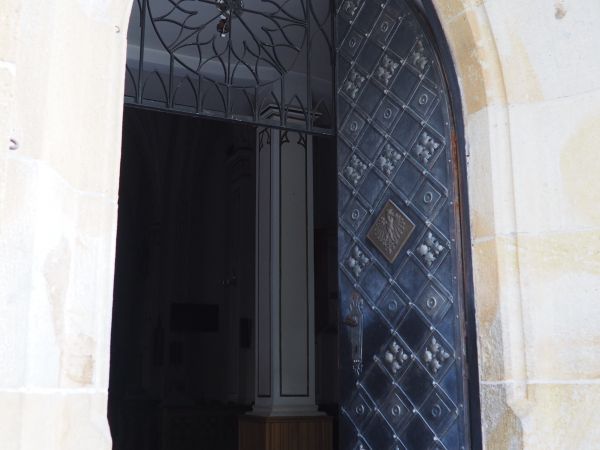 wejście główne do kościoła zdrojowego - wyposażone w silne, mocne kute blachą drzwi, które w kasetonie zdobi piastowski orzeł.