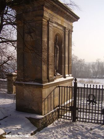 Pylon z postacią Imiennika obiektu