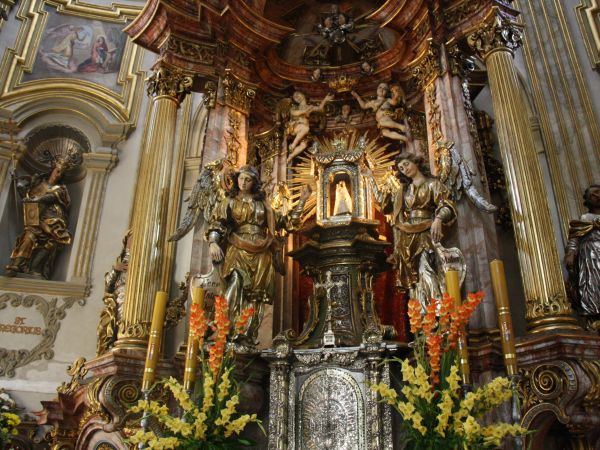 ołtarz główny w bazylice, późnobarokowy. Nad tabernakulum : adorowana przez dwa anioły rzeźba Madonny z Dzieciątkiem. Figurka wykonana z drewna lipowego ma 28 c