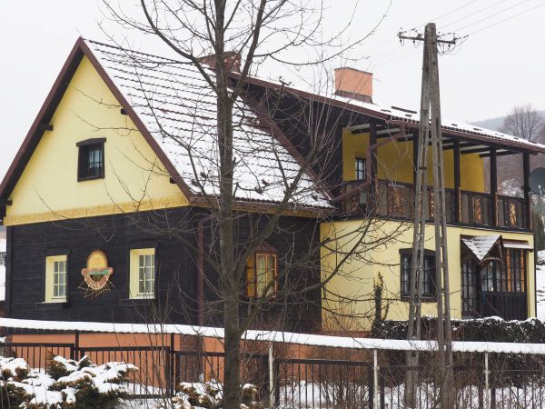 ciekawa, niepowtarzalna bryła budynku mieszkalnego, wspartego na wysokiej podmurówce, duże powierzchnie ścian i szczyt szalowane deskami - no i weranda, czyżby