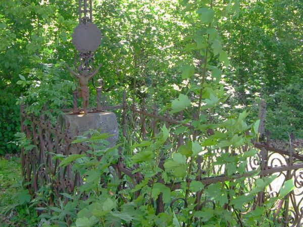 na starym przycerkiewnym cmentarzu: kamienne nagrobki, otoczone kutymi płotkami i wyróżniające się okazałymi krzyżami.