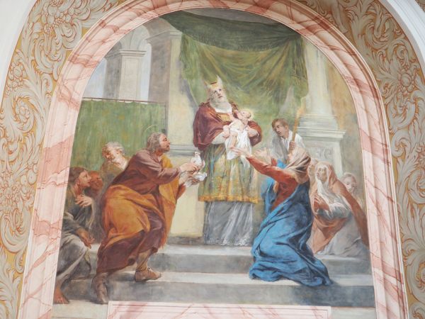 w najświętszym dla wszystkich Żydów miejscu, w Jerozolimie : tu scena przedstawia ofiarowanie Pierworodnego kapłanom w świątyni. Św. Józef trzyma w ręce gołębia