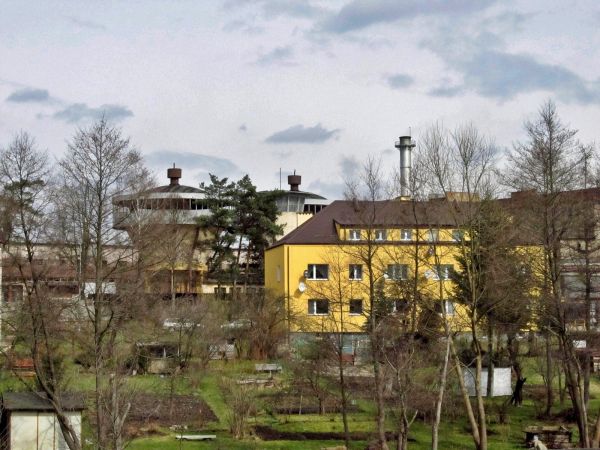 Widok z terenu przedszkola na stożki w zakładzie Steico oraz na blok mieszkalny "awaryjny"