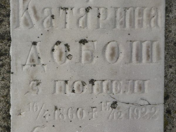 na cmentarzu parafialnym - zabytkowe nagrobki - na zdjęciu: nagrobna tablica, czytelne bukwy cyrylicy - tj. rzeźbione napisy i oznaki pochodzenia  /herby/ na na