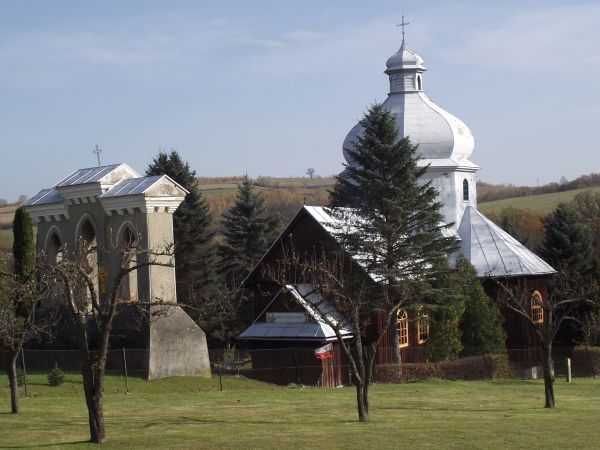 po wojnie: kościół i tak do dziś, wcześniej cerkiew wyznawców obrządku grecko-katolickiego, obok / przed : dzwonnica. Flaga państwowa przy świątyni, msza święta