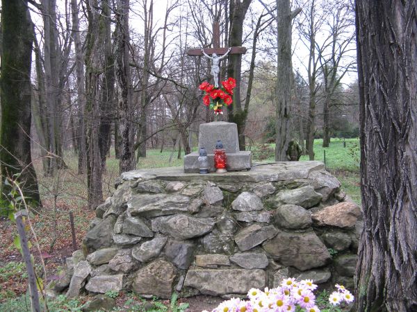 krzyż na betonowym cokole, zwieńczający kurhan kamienny zespolony - w parku. Na nim znicze, kwiaty świeże. Może mogiła powstańcza? /ubogi przekaz/.