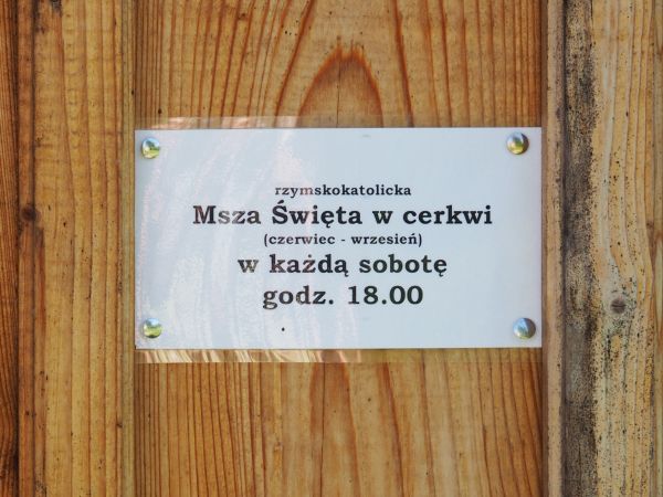 na drzwiach cerkwi : informacja o mszy odprawianej dla wyznawców obrządku rzymsko-katolickiego - a niech przyświeci temu przesłanie : "Jesteśmy dziećmi jednego